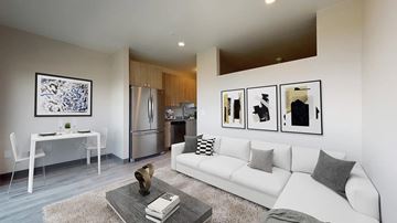 Denver apartment for rent - A modern living room with a white couch and a coffee table.