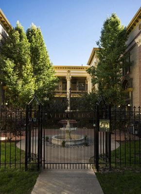 Denver apartment for rent - a wrought iron gate with a fountain in front of a building