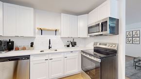 Arvada apartment for rent - A modern kitchen with white cabinets and stainless steel appliances.