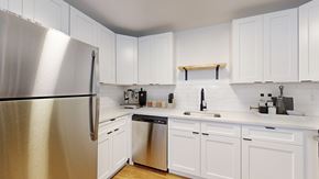 Arvada apartment for rent - A kitchen with white cabinets and a stainless steel refrigerator.