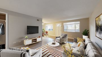 Denver apartment for rent - A living room with a grey couch, a white coffee table, and a television on the wall.