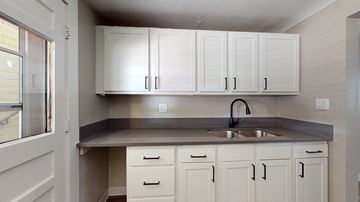 Denver apartment for rent - A kitchen with white cabinets and a stainless steel sink.
