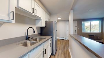 Denver apartment for rent - A kitchen with white cabinets and a stainless steel refrigerator.
