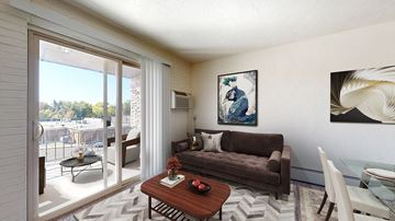 Littleton apartment for rent - A living room with a brown couch, a coffee table, and a painting on the wall.