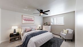 Arvada apartment for rent - A bedroom with a bed, a chair, and a ceiling fan.