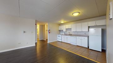 Denver apartment for rent - A kitchen area with white cabinets and a yellow line on the floor.