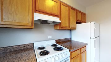 Denver apartment for rent - A kitchen with a white stove and wooden cabinets.