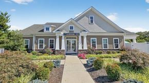 York townhouse for rent - A building with a sign that reads 26000 is surrounded by bushes and flowers.