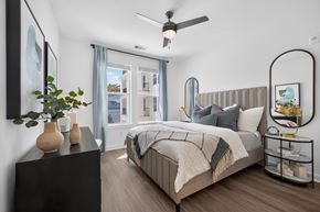 Jacksonville apartment for rent - A bedroom with a large bed and a ceiling fan.