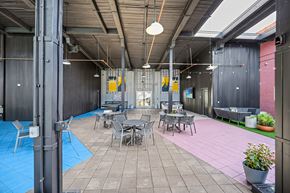Winston-Salem apartment for rent - A patio with tables and chairs is surrounded by a blue mat.