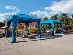 Gastonia apartment for rent - a group of blue gazebos with chairs and tables under them