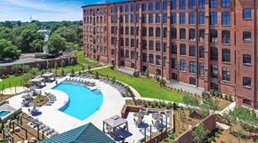 Gastonia apartment for rent - an aerial view of a large brick building with a large pool in front of it