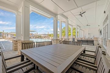 St Augustine apartment for rent - A wooden table is in the middle of a patio with a pool in the background.