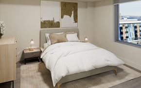 Halifax apartment for rent - A bedroom with a large bed and a view of the city.