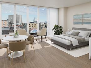 Halifax apartment for rent - A modern bedroom with a large bed and a view of the city.