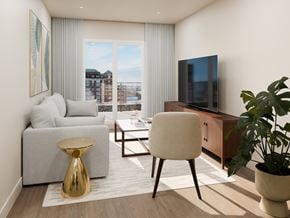 Halifax apartment for rent - A modern living room with a grey sofa, a white chair, a gold stool, and a television.