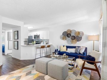 Boca Raton apartment for rent - A modern living room with a blue couch and a wooden chair.