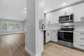 Plantation apartment for rent - A kitchen with white cabinets and a wooden floor.