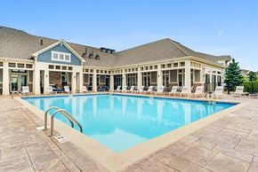 Vernon Hills apartment for rent - Luxury Apartments In Vernon Hills, IL - The Oaks of Vernon Hills - Resort-Style Swimming Pool With Lounge Chairs, And Resident Clubhouse In The Background