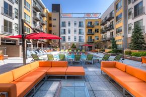 Denver apartment for rent - an outdoor lounge area with tables and chairs in an apartment building