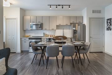 Riverview apartment for rent - A modern kitchen with a dining table set for four.