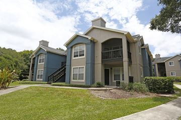 Palm Harbor apartment for rent - A blue and beige two-story apartment building with a staircase leading to the second floor.