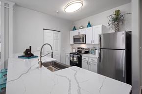 Raleigh apartment for rent - A kitchen with a marble counter top and stainless steel appliances.