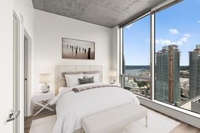 Seattle apartment for rent - A bedroom with a large bed and a view of the city.
