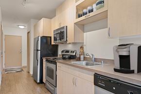 Seattle apartment for rent - A kitchen with a black fridge, black oven, black microwave, black dishwasher and black coffee maker.