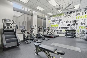 Pasadena apartment for rent - A gym with a variety of equipment and a motivational word cloud on the wall.