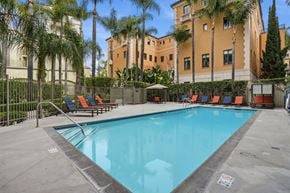 Pasadena apartment for rent - A pool surrounded by palm trees and lounge chairs.