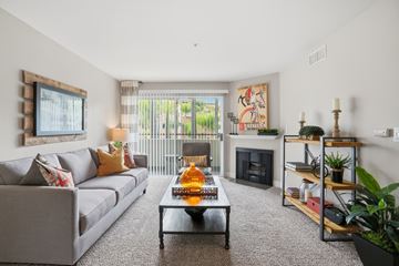 Pasadena apartment for rent - A living room with a grey couch, a coffee table, a fireplace, and a painting on the wall.