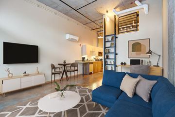 Seattle apartment for rent - A living room with a blue couch and a television on the wall.