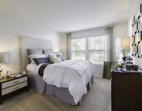 Germantown apartment for rent - A bedroom with a large bed and a nightstand with a lamp.