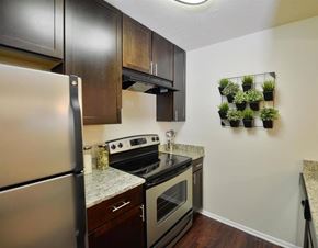 Germantown apartment for rent - A kitchen with a stainless steel refrigerator, a stove top oven, and a wall-mounted herb garden.