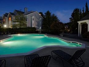 Alexandria apartment for rent - A pool surrounded by chairs and a house in the background.