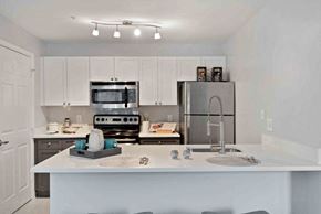 Alexandria apartment for rent - A kitchen with white cabinets and a white island with a sink.