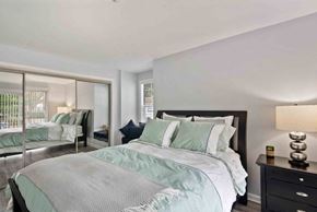 Alexandria apartment for rent - A bedroom with a large bed and a nightstand with a lamp.