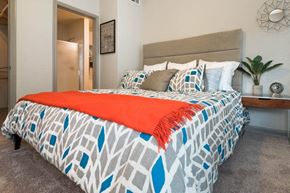 Austin apartment for rent - a bedroom with a bed and a potted plant