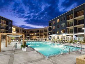 Atlanta apartment for rent - A large swimming pool surrounded by apartment buildings at dusk.