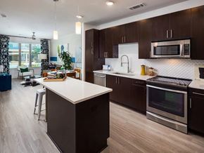 Atlanta apartment for rent - A modern kitchen with dark brown cabinets and a white island.