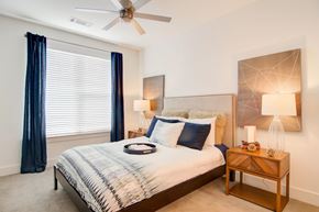 Atlanta apartment for rent - A bedroom with a bed, nightstand, and a ceiling fan.