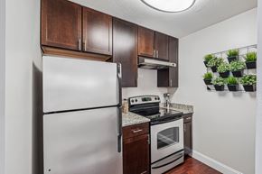 Germantown apartment for rent - A kitchen with a white refrigerator and a stove top oven.