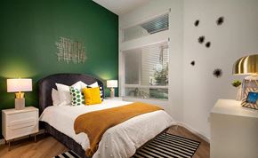 Fullerton apartment for rent - a bedroom with a bed and a green wall