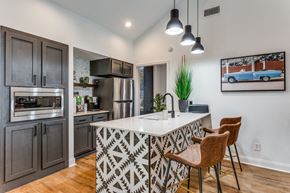 Austin apartment for rent - a kitchen with a large center island with a sink and two stools