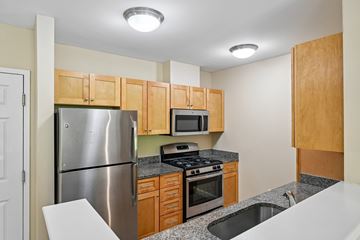 Littleton apartment for rent - A kitchen with a stainless steel refrigerator, microwave, oven, and sink.