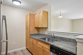 Littleton apartment for rent - A kitchen with wooden cabinets and granite countertops.