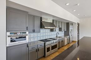 Austin apartment for rent - A modern kitchen with dark grey cabinets and stainless steel appliances.