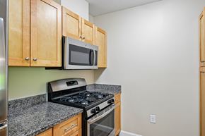 Littleton apartment for rent - A kitchen with a stove, microwave, and cabinets.
