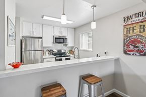 San Jose apartment for rent - A kitchen with white cabinets and a fridge.